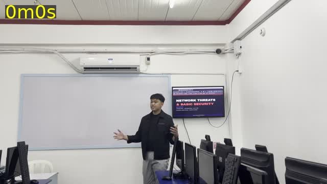 Joshua Cervantes presenting an IT lesson with slides to a class in a computer lab